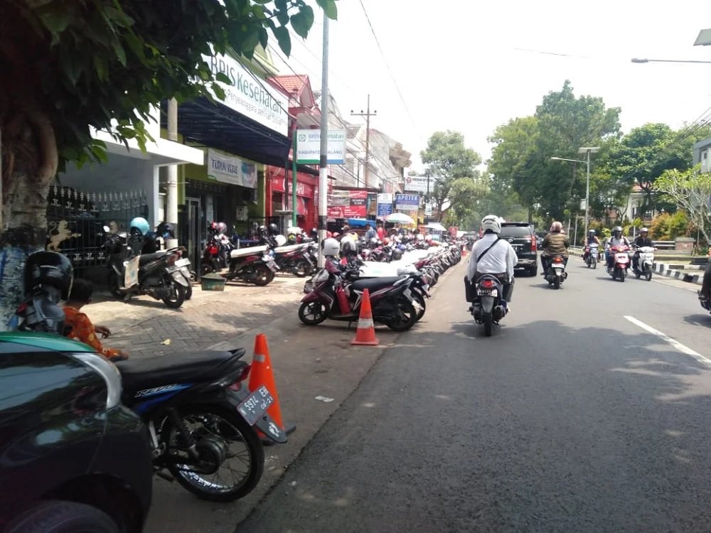 078-Motorcycle parking in front of office buildings on Jalan Panji, Kepanjen “No More Cash, Please”: Malang Introduces Mandatory QRIS for Over 1,000 Parking Attendants