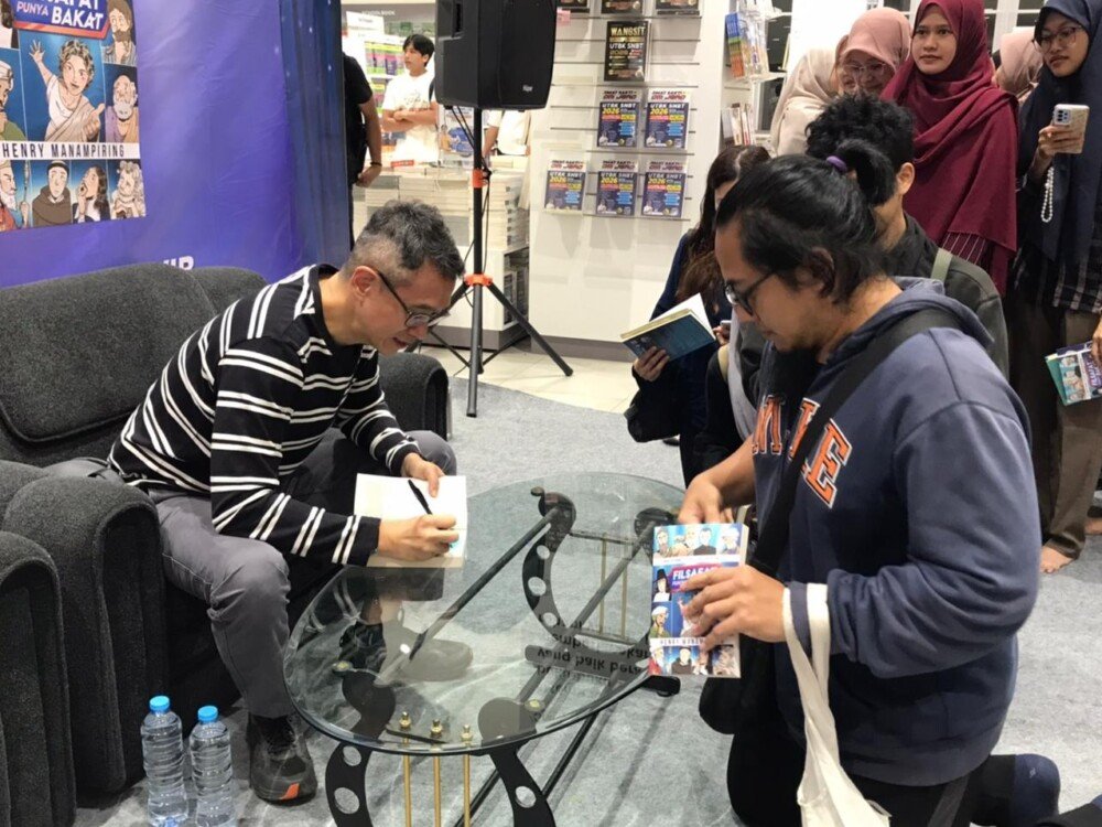 Henry Manampiring signing books for readers after the book tour event at Gramedia Kayutangan, Malang, on Friday, 12 December 2025. (Photo credit: Anggraeni Juwita)