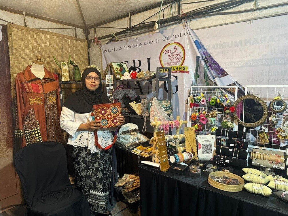 Ayu Agustina Irianti showcasing her handmade knitted bag products from Peri Elang, one of the festival's standout attractions at Kepandjen Djaman Mbiyen.
(Photo credit: Riznima Azizah Noer)