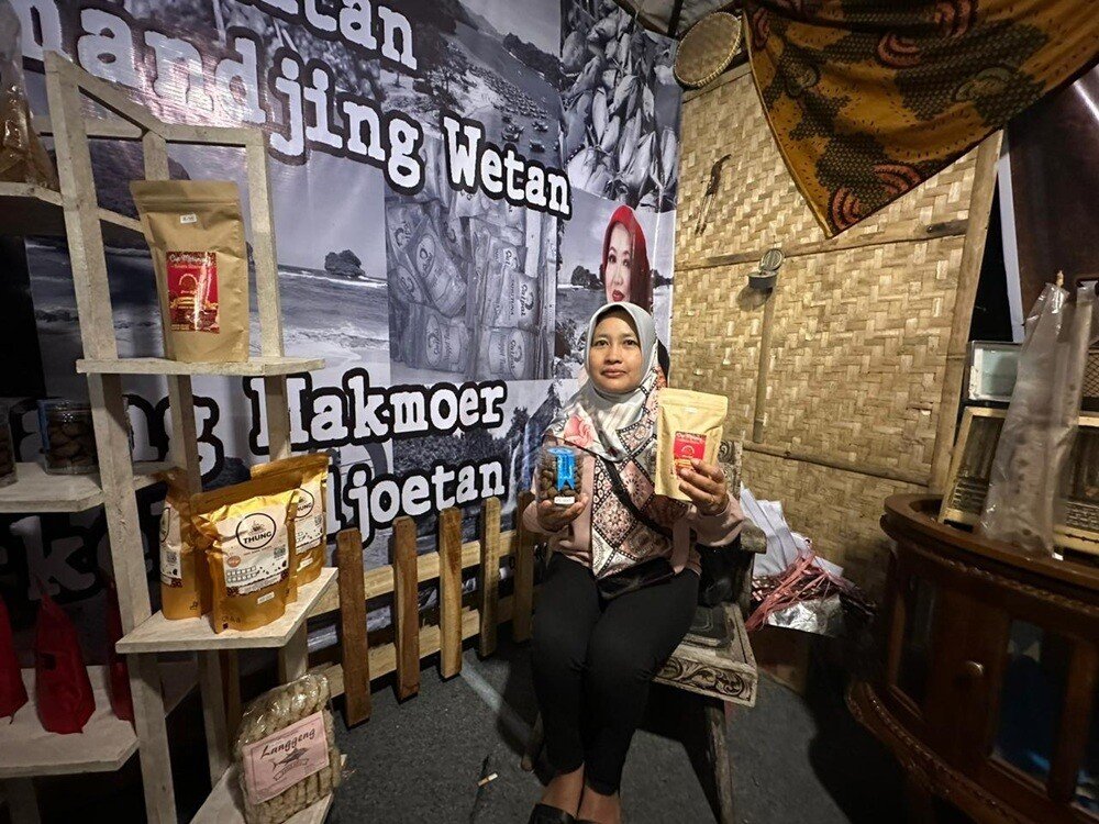 Ani Suprihatin promoting chocolate-coffee cakes and specialty coffee powder unique from Sumbermanjing Wetan at the Kepandjen Djaman Mbiyen Festival.
(Photo credit: Riznima Azizah Noer)